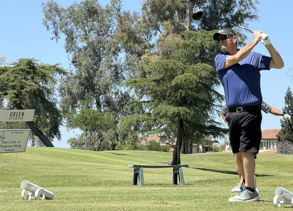A golfer mid-swing at the Golf for Life tournament